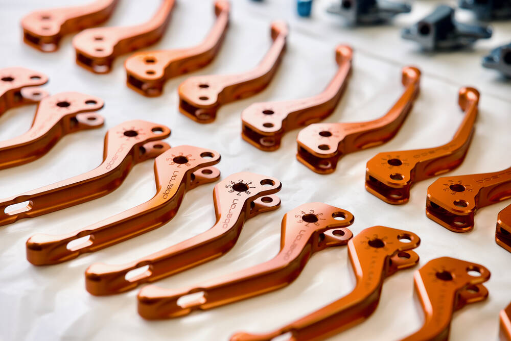 Orange anodised aluminium levers on a white background